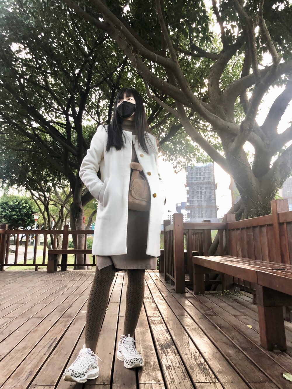 ブラウン系のワンピース/ドレス、ブラウン系のドラムバッグ、ベージュ系のスニーカーを着用したレディースの冬コーディネートの3枚目の写真