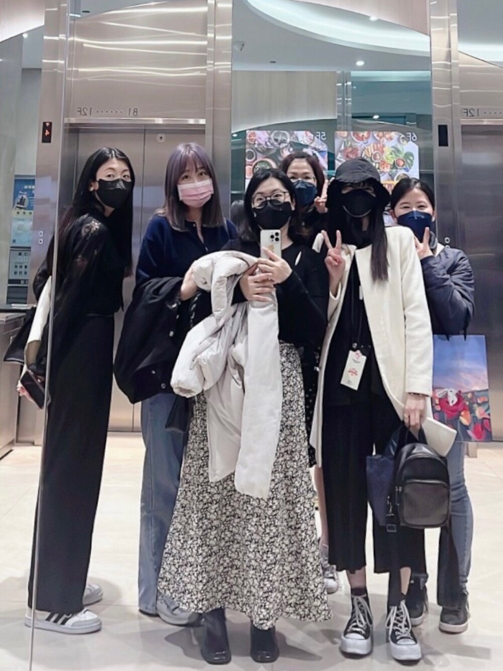 ブラック系のトップス、ブラック系のバックパック/リュック、ブラック系のシューズを着用したレディースの冬コーディネートの2枚目の写真