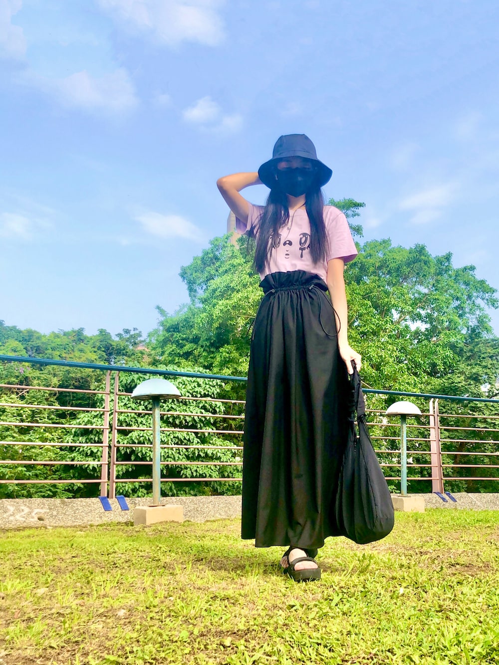 パープル系のTシャツ/カットソー、ブラック系のスカート、ブラック系のバッグを着用したレディースの夏コーディネートの4枚目の写真