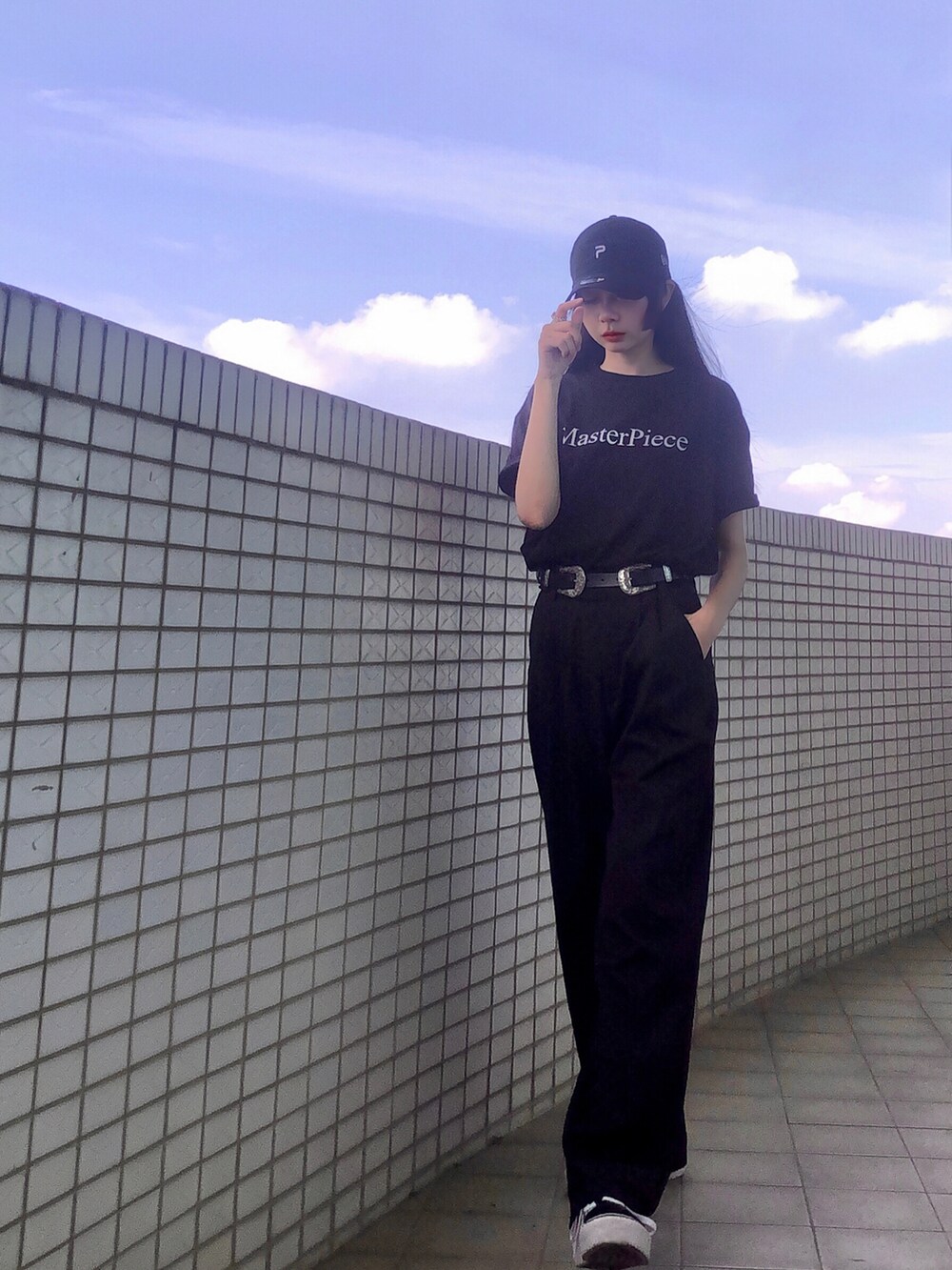 ブラック系のTシャツ/カットソー、ブラック系のスーツパンツ、ブラック系のスニーカーを着用したレディースの夏コーディネートの2枚目の写真