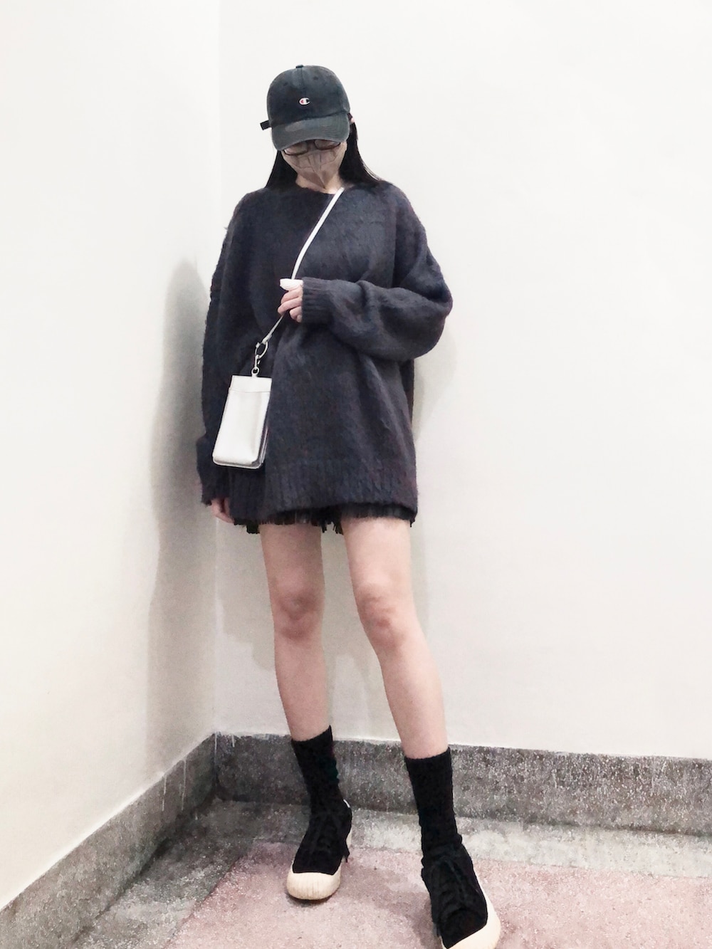 ブルー系のニット/セーター、シルバー系のショルダーバッグ、ブラック系のスニーカーを着用したレディースの冬コーディネートの2枚目の写真