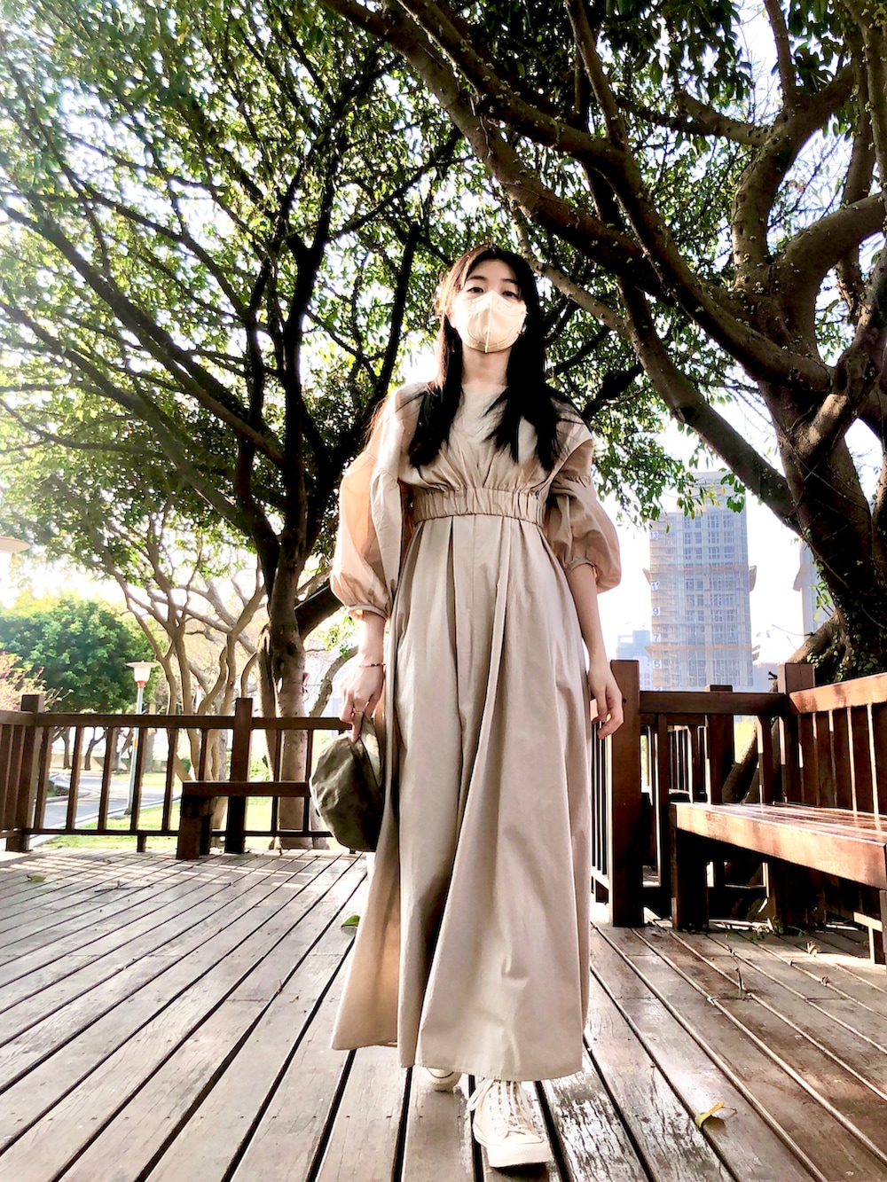 ベージュ系のワンピース、ブラック系のバッグ、ゴールド系のシューズを着用したレディースの春コーディネートの2枚目の写真