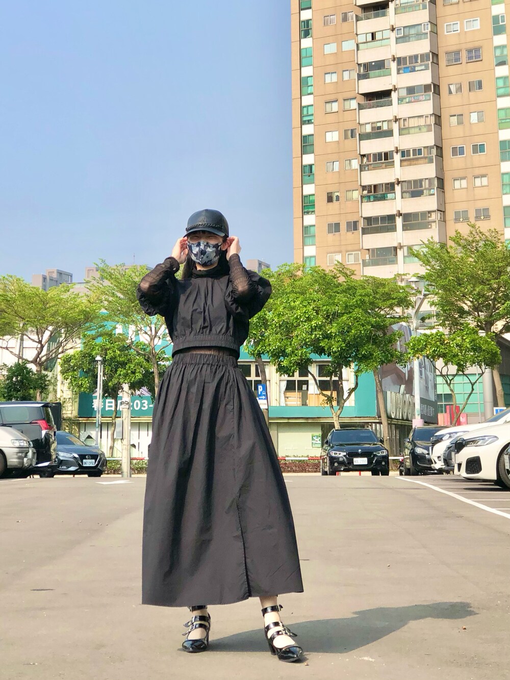 ブラック系のトップス、ブラック系のスカート、ブラック系のシューズを着用したレディースの春コーディネートの2枚目の写真