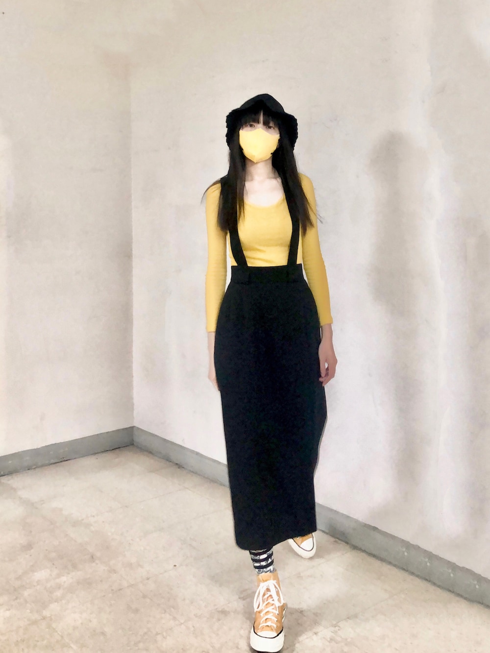 イエロー系のスニーカー、ベージュ系のその他アウター、ブラック系のキャップを着用したレディースの冬コーディネートの2枚目の写真