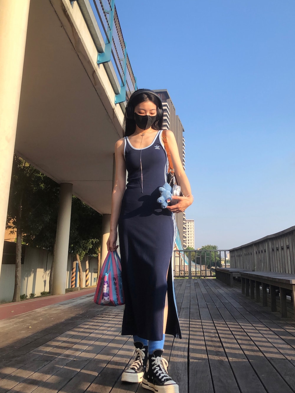 ブルー系のその他アウター、ブルー系のジャンパースカート、ブラウン系のショルダーバッグを着用したレディースの秋コーディネートの2枚目の写真