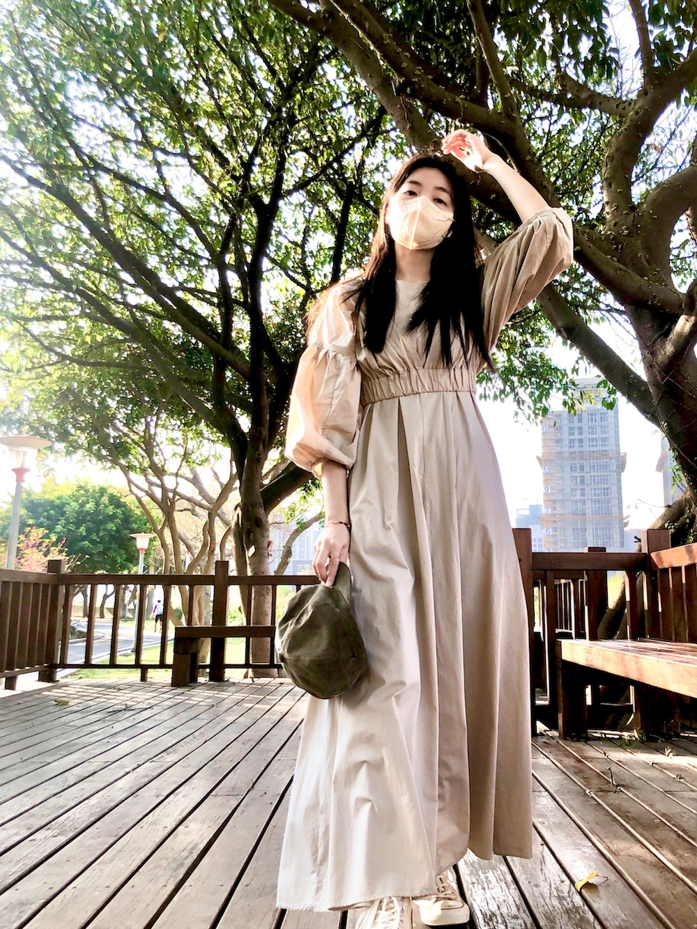 ベージュ系のワンピース、ブラック系のバッグ、ゴールド系のシューズを着用したレディースの春コーディネートの3枚目の写真