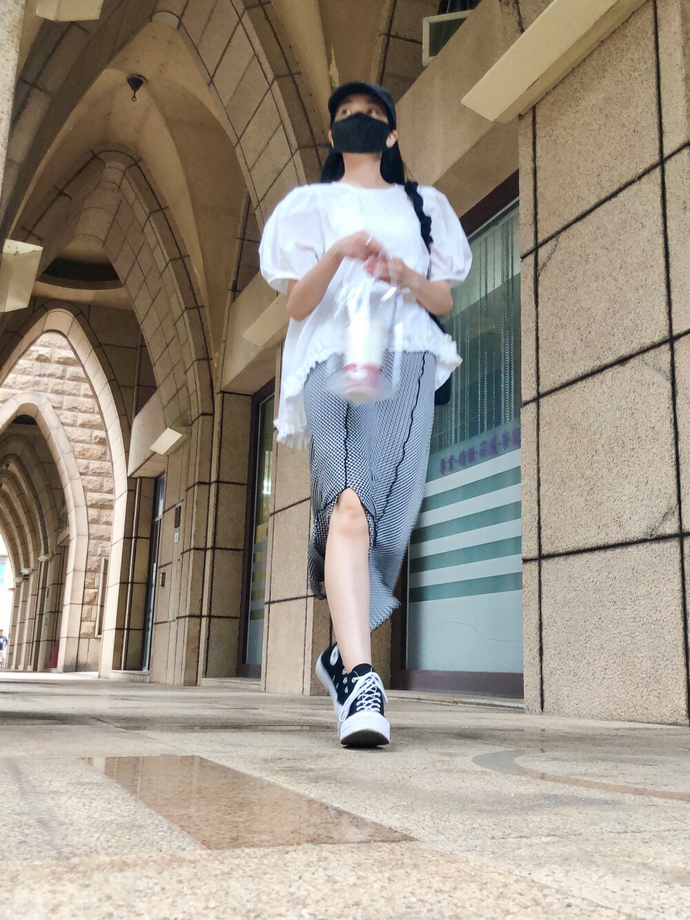 ホワイト系のトップス、ブラック系のスーツセット、ブラック系のバッグを着用したレディースの夏コーディネートの5枚目の写真