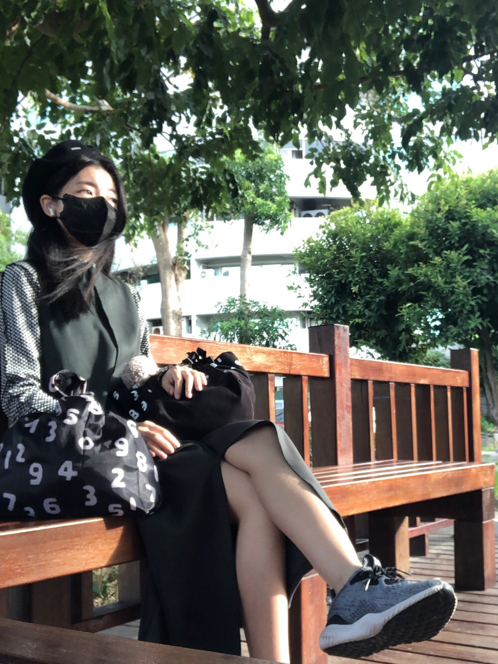 ブラック系のTシャツ/カットソー、グリーン系のジャンパースカート、ブラック系のバッグを着用したレディースの秋コーディネートの3枚目の写真