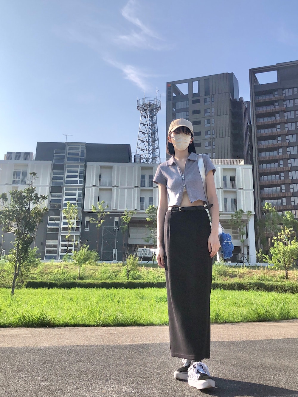 ブラック系のスニーカー、グレー系のポロシャツ、ブラック系のスカートを着用したレディースの夏コーディネートの3枚目の写真