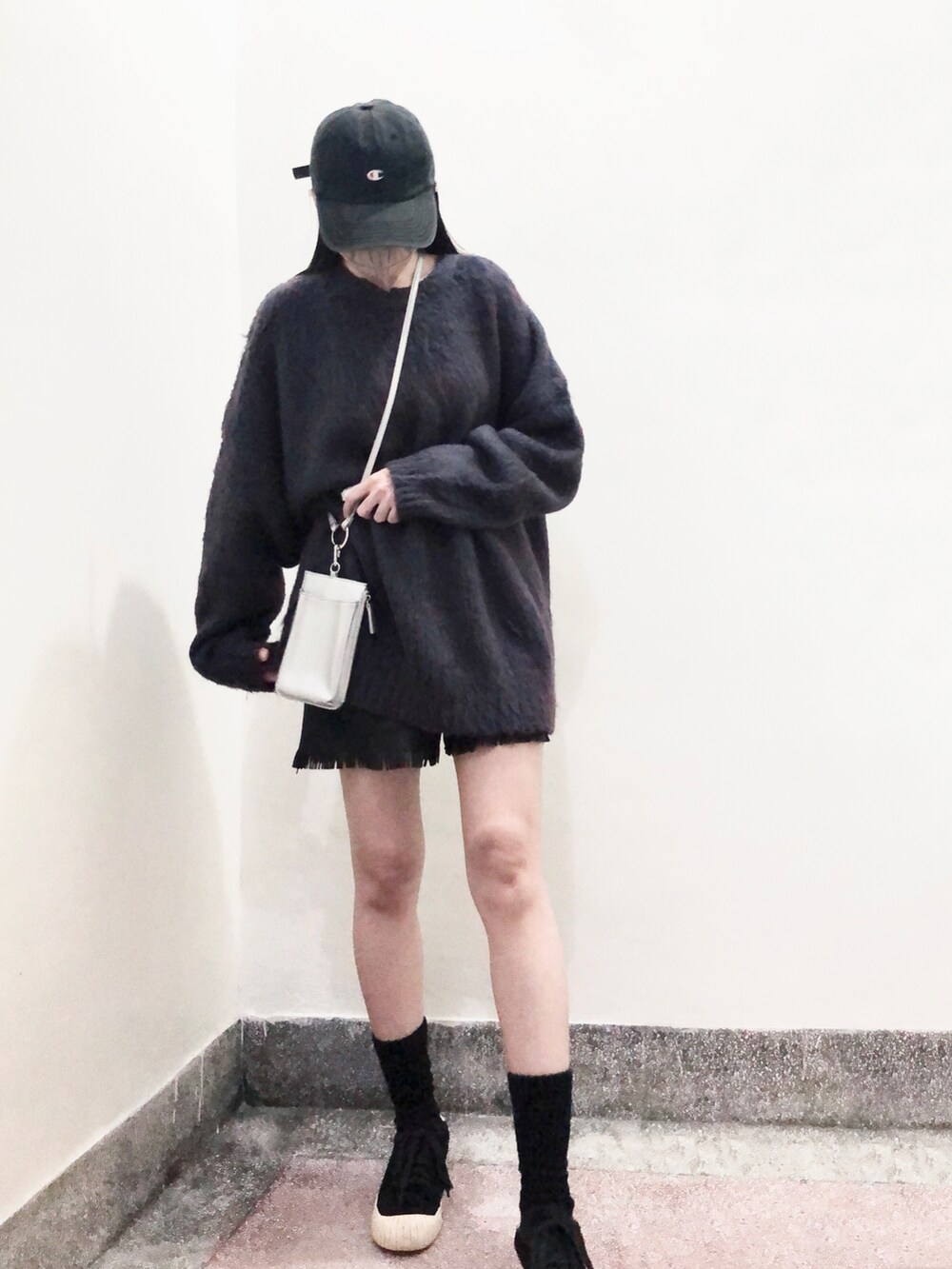 ブルー系のニット/セーター、シルバー系のショルダーバッグ、ブラック系のスニーカーを着用したレディースの冬コーディネートの3枚目の写真