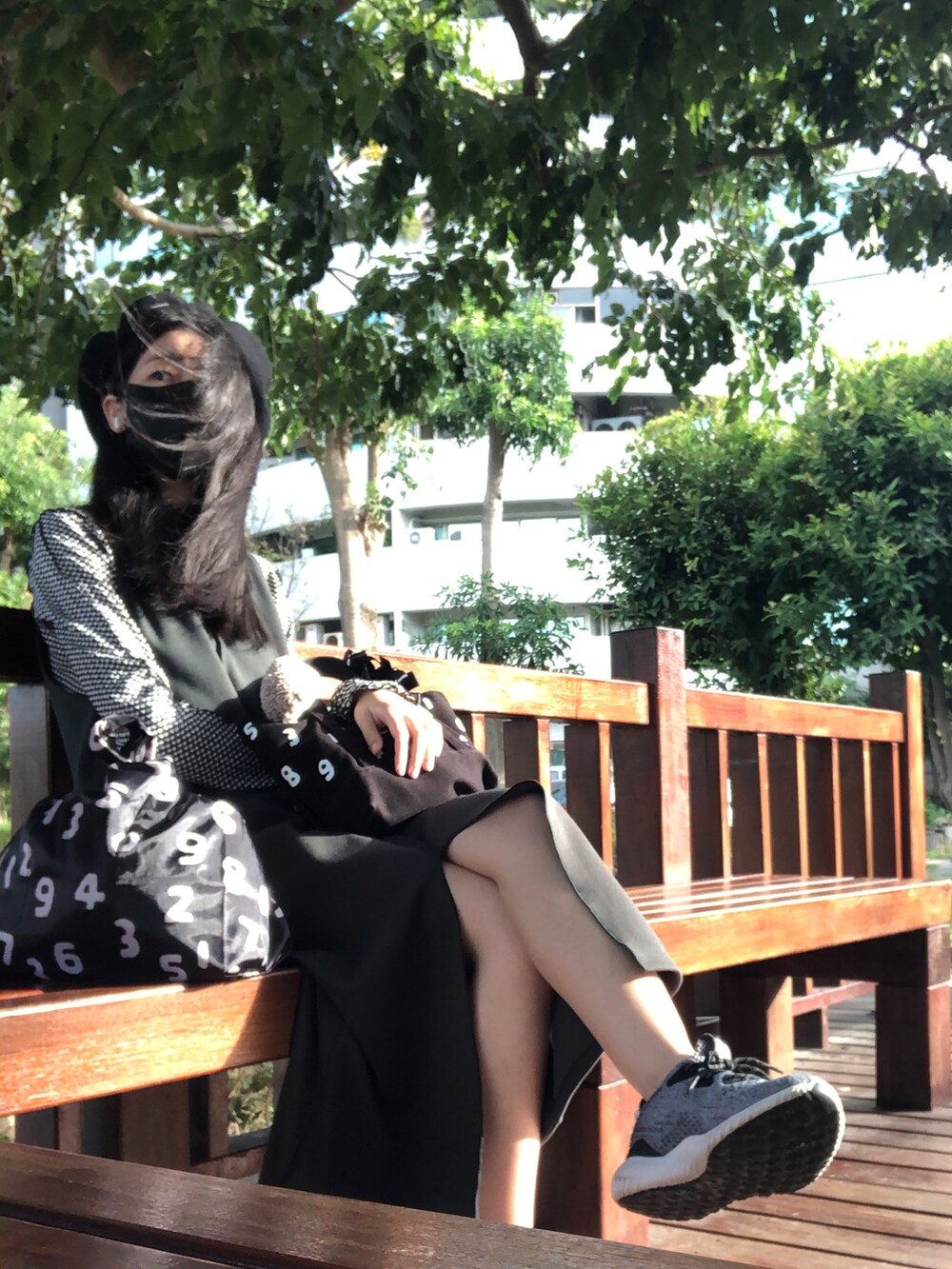 ブラック系のTシャツ/カットソー、グリーン系のジャンパースカート、ブラック系のバッグを着用したレディースの秋コーディネートの4枚目の写真