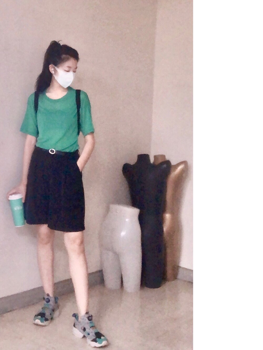 グリーン系のトップス、ブラック系のバックパック/リュック、ブラック系のカーゴパンツを着用したレディースの夏コーディネートの2枚目の写真