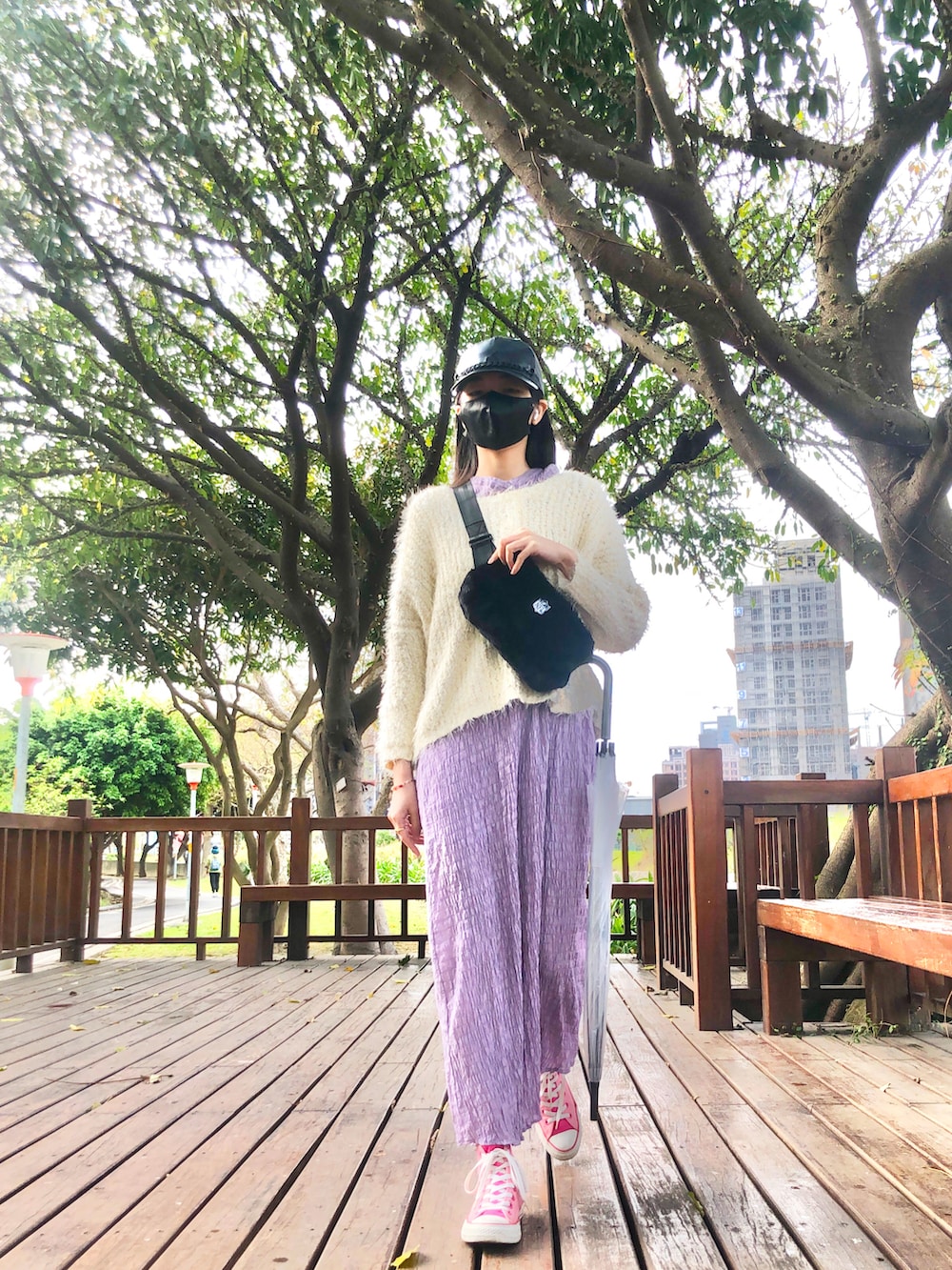 ホワイト系のニット/セーター、ブラック系のボディバッグ/ウエストポーチ、パープル系のワンピースを着用したレディースの春コーディネートの2枚目の写真