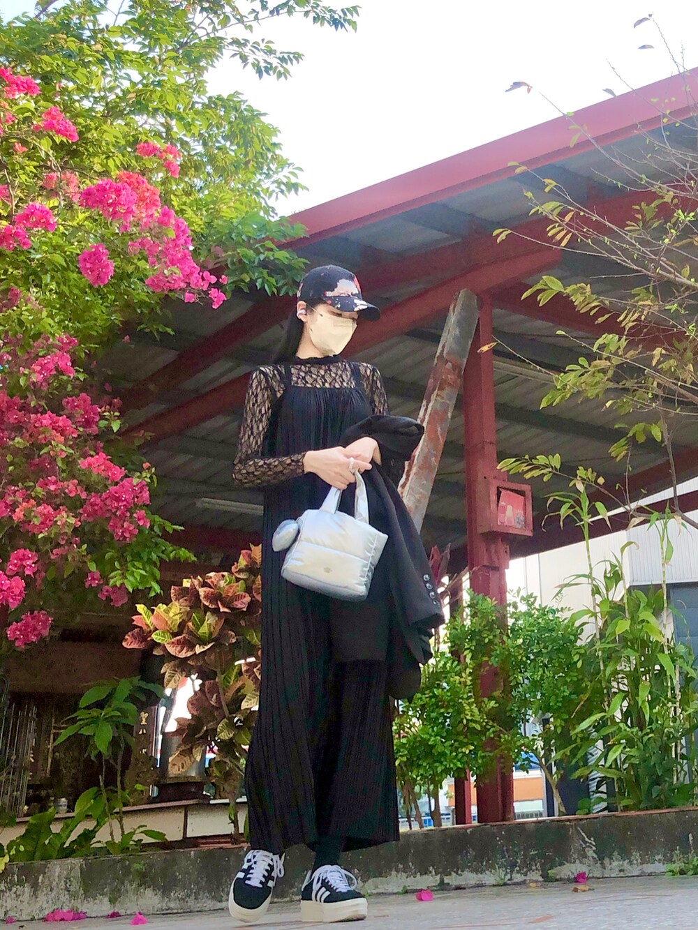 ブラック系のTシャツ/カットソー、ブラック系のジャンパースカート、ブラック系のスーツジャケットを着用したレディースの春コーディネートの4枚目の写真
