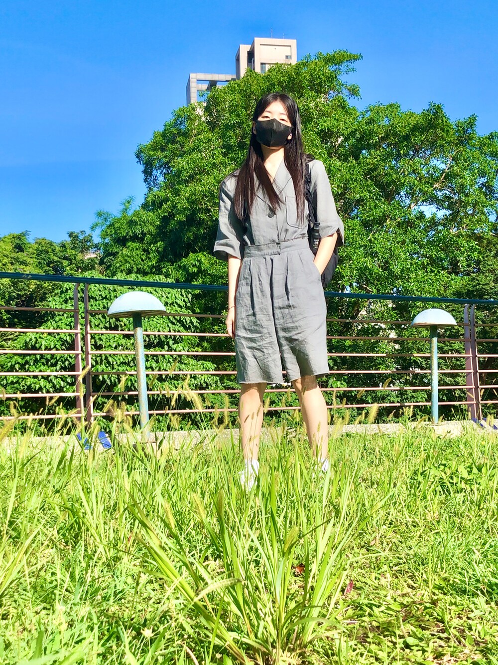 グレー系のスーツセット、ブラック系のバッグ、ホワイト系のスポーツブラを着用したレディースの夏コーディネートの2枚目の写真