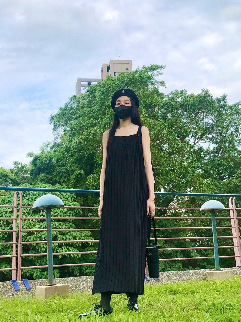 ブラック系のジャンパースカート、ブラック系のバッグ、ブラック系のハンチング/ベレー帽を着用したレディースの夏コーディネートの4枚目の写真