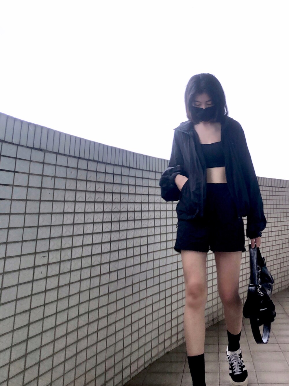ブラック系のスニーカー、ブラック系のチューブトップ、ブラック系のその他アウターを着用したレディースの秋コーディネートの3枚目の写真