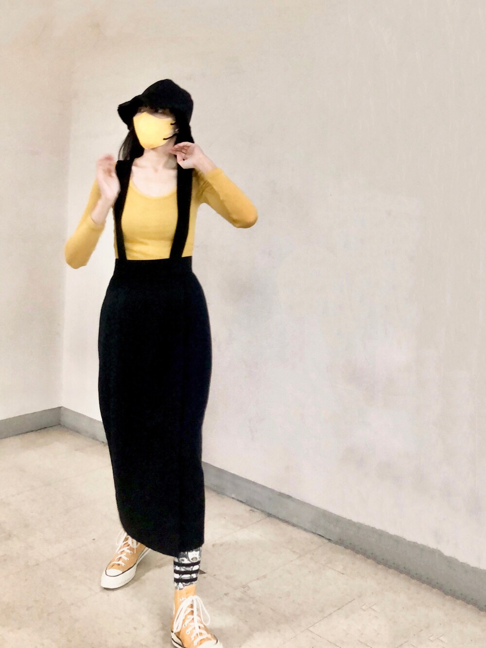 イエロー系のスニーカー、ベージュ系のその他アウター、ブラック系のキャップを着用したレディースの冬コーディネートの3枚目の写真