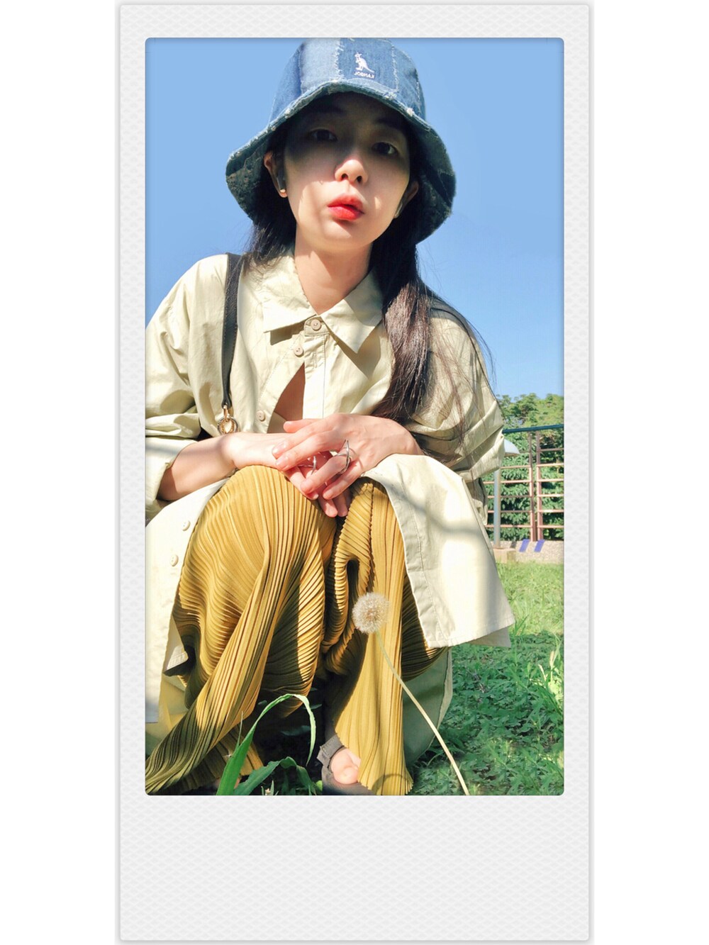 グリーン系のシャツワンピース、ゴールド系のパンツ、ブラック系のバッグを着用したレディースの春コーディネートの2枚目の写真