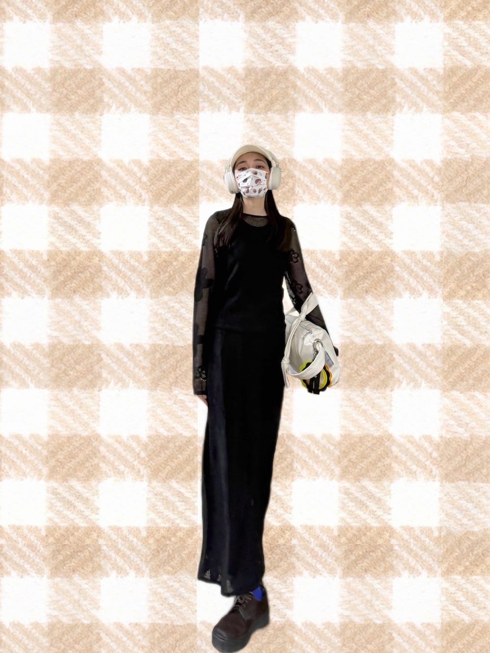 ブラック系のニット/セーター、ブラック系のスカート、ブラック系のジャンパースカートを着用したレディースの春コーディネートの2枚目の写真