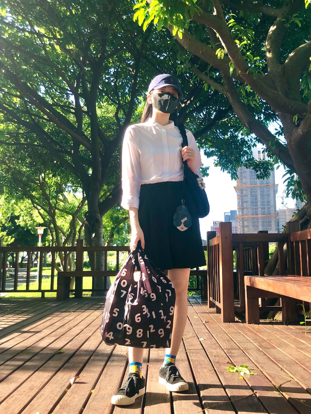 ブラック系のバッグ、ブラック系のカーゴパンツ、ブラック系のバッグを着用したレディースの夏コーディネートの2枚目の写真