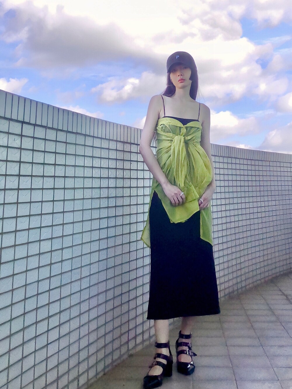 ブラック系のジャンパースカート、グリーン系のシャツ/ブラウス、シルバー系のバッグを着用したレディースの夏コーディネートの2枚目の写真