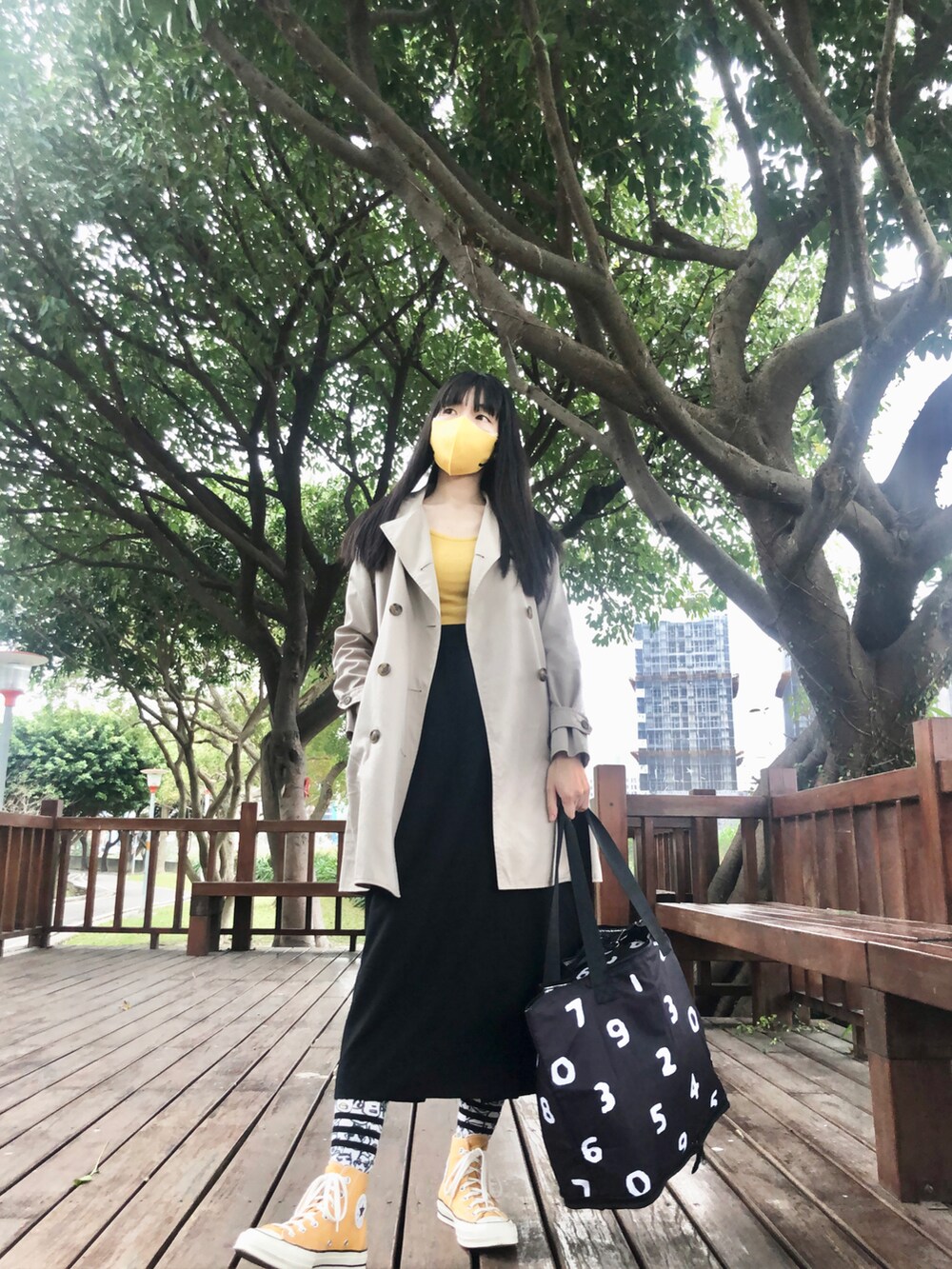 イエロー系のスニーカー、ベージュ系のその他アウター、ブラック系のキャップを着用したレディースの冬コーディネートの4枚目の写真