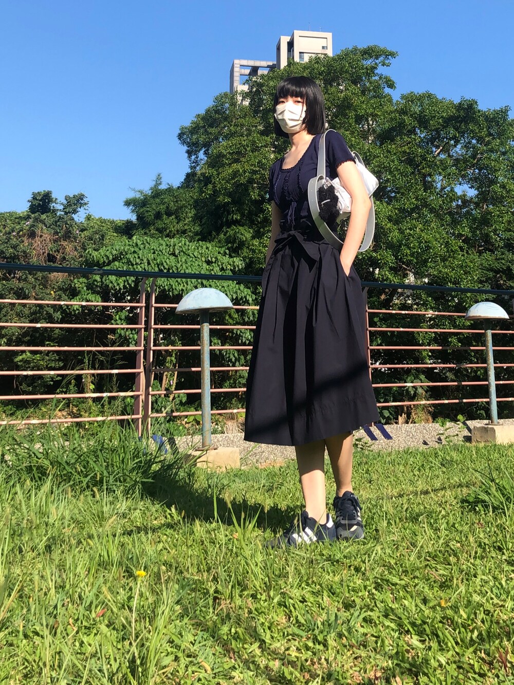 ブルー系のスニーカー、ブルー系のスカート、その他のショルダーバッグを着用したレディースの夏コーディネートの3枚目の写真