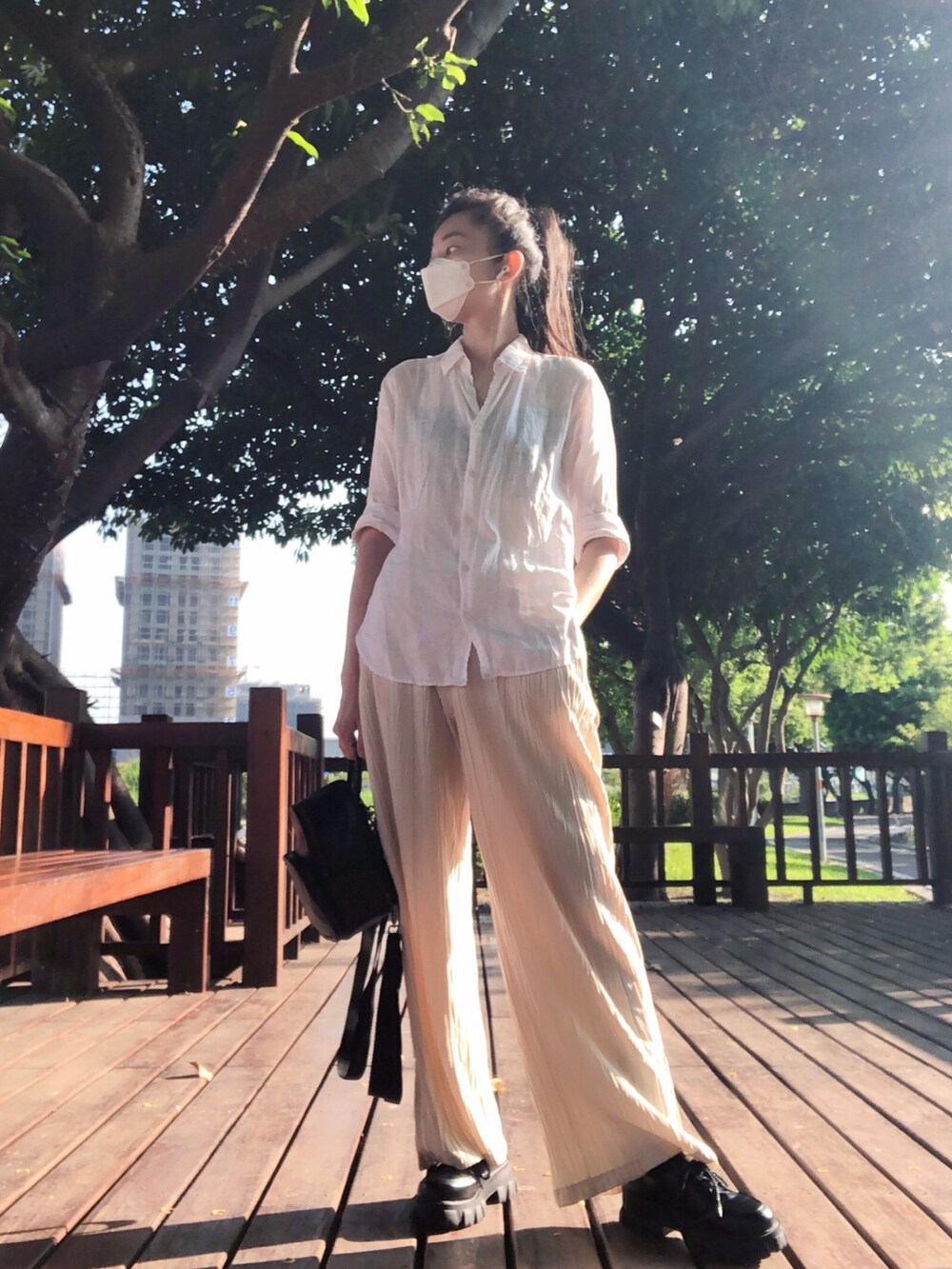 ホワイト系のシャツ/ブラウス、ベージュ系のつなぎ/オールインワン、ブラック系のバックパック/リュックを着用したレディースの夏コーディネートの2枚目の写真
