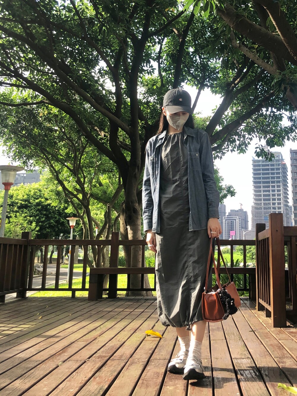 ブルー系のシャツ/ブラウス、グレー系のジャンパースカート、その他のショルダーバッグを着用したレディースの春コーディネートの3枚目の写真