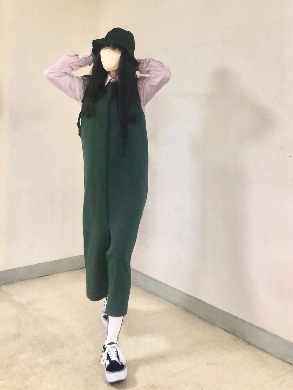 ピンク系のシャツ/ブラウス、グリーン系のジャンパースカート、ブラック系のスニーカーを着用したレディースの冬コーディネートの2枚目の写真