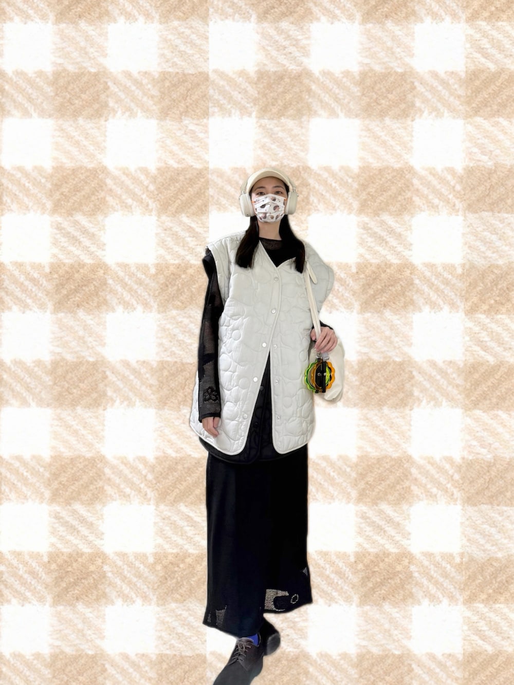 ブラック系のニット/セーター、ブラック系のスカート、ブラック系のジャンパースカートを着用したレディースの春コーディネートの4枚目の写真