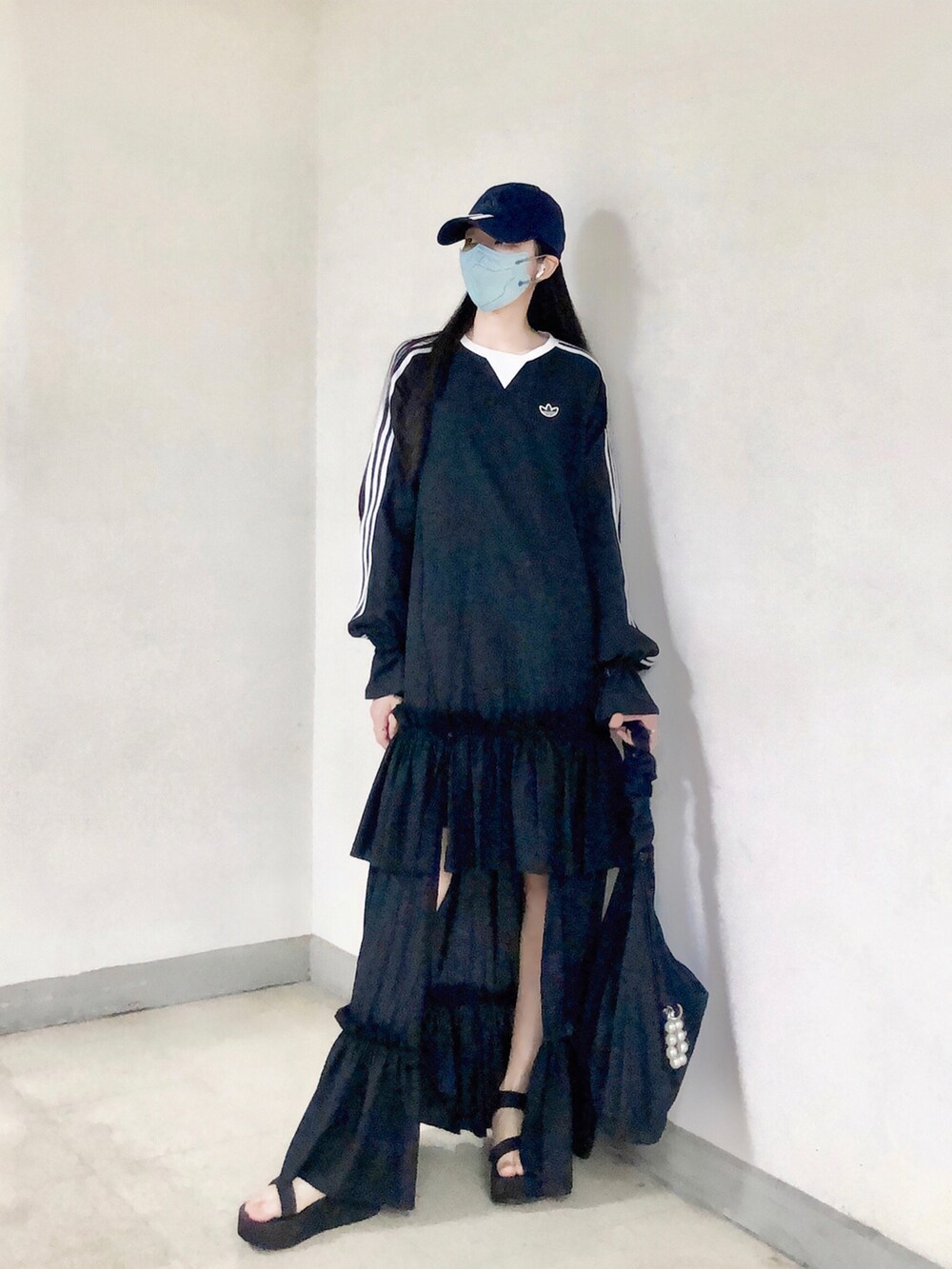 ブラック系のワンピース、ブラック系のバッグ、ブラック系のサンダルを着用したレディースの夏コーディネートの4枚目の写真