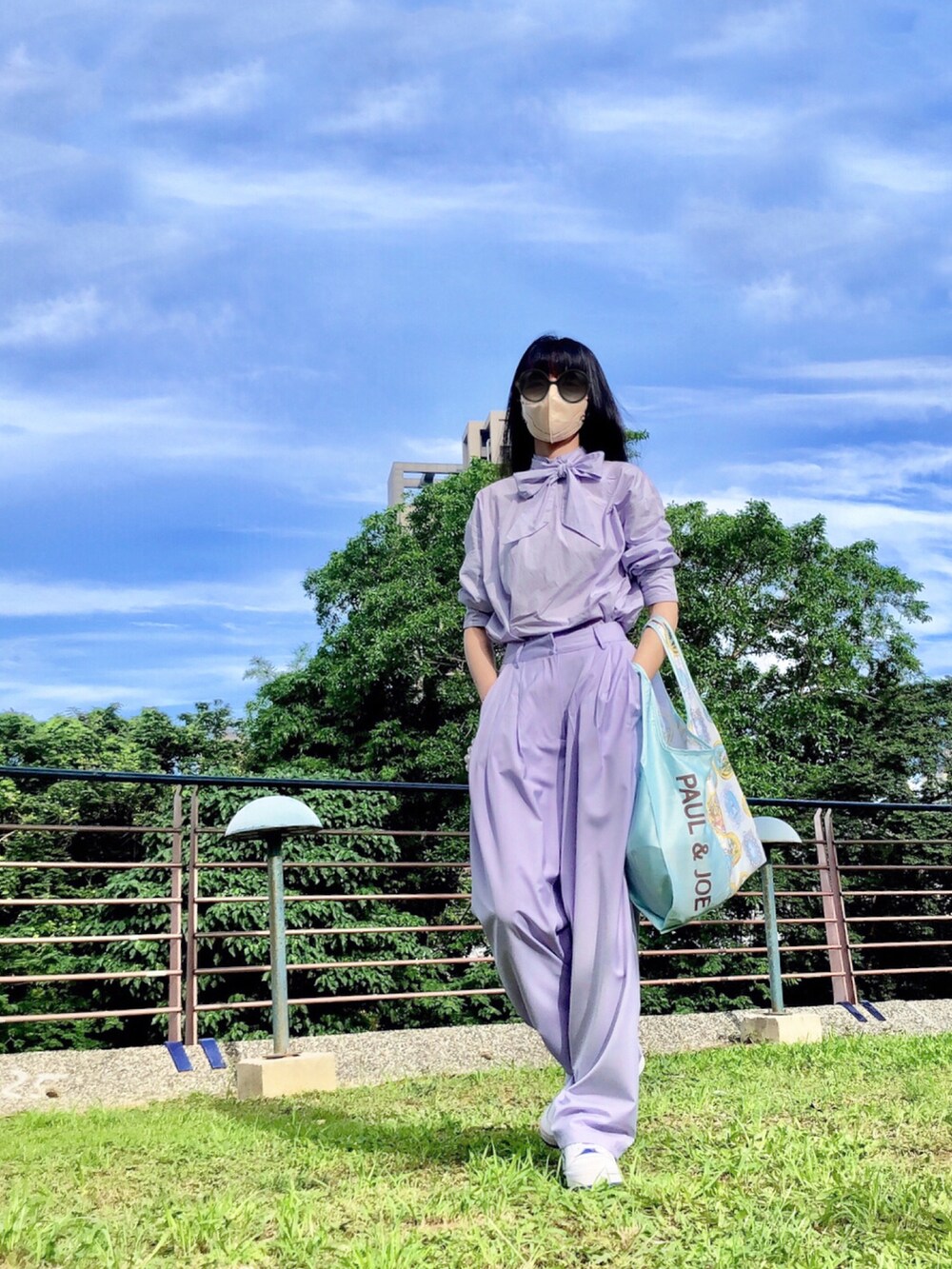 パープル系のシャツ/ブラウス、パープル系のスーツパンツ、ホワイト系のスニーカーを着用したレディースの夏コーディネートの3枚目の写真