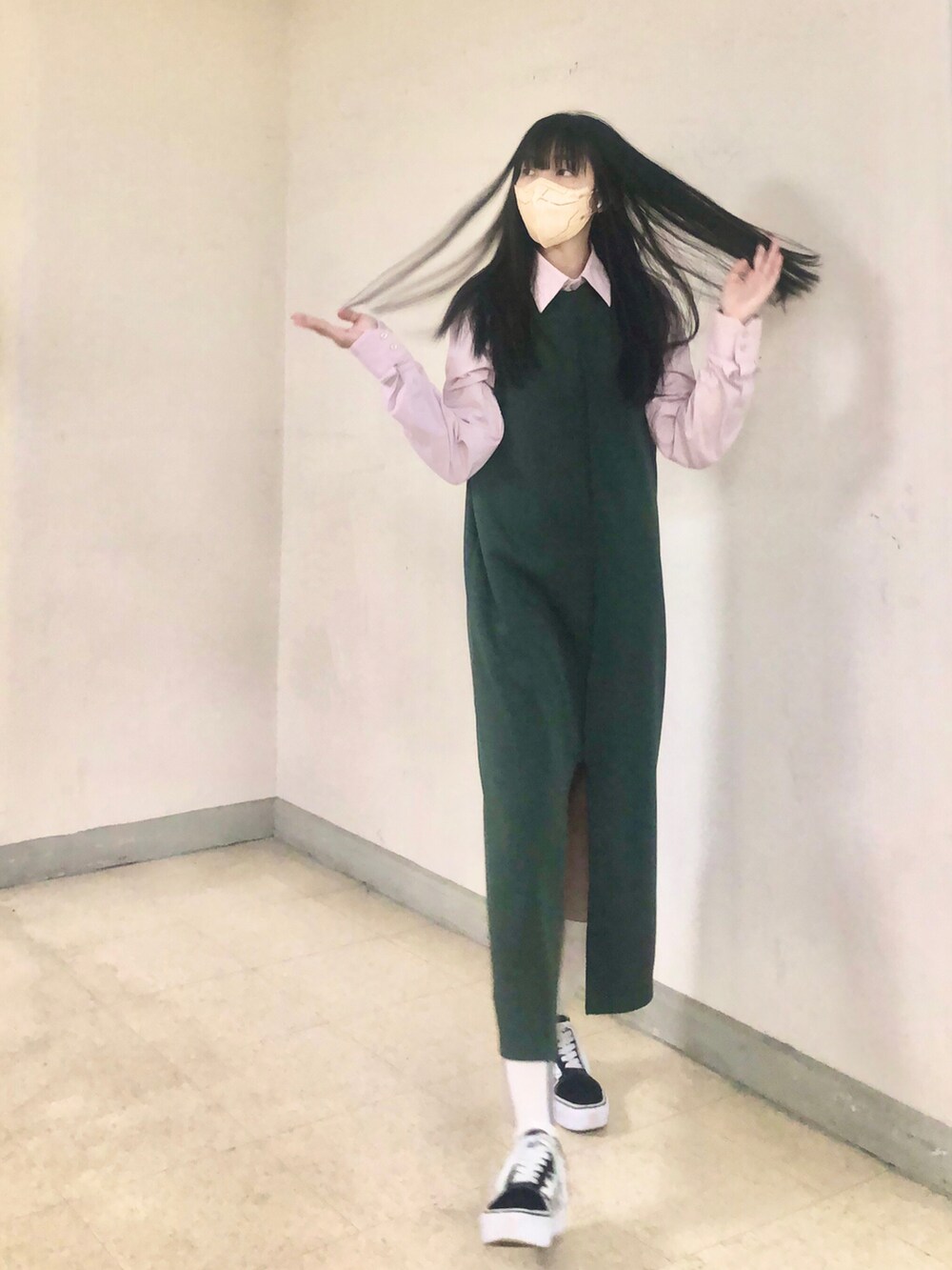 ピンク系のシャツ/ブラウス、グリーン系のジャンパースカート、ブラック系のスニーカーを着用したレディースの冬コーディネートの4枚目の写真