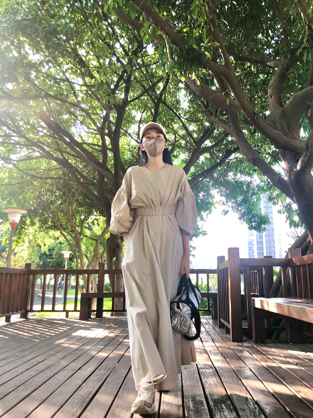 ベージュ系のワンピース、ベージュ系のスニーカー、シルバー系のバッグを着用したレディースの秋コーディネートの2枚目の写真