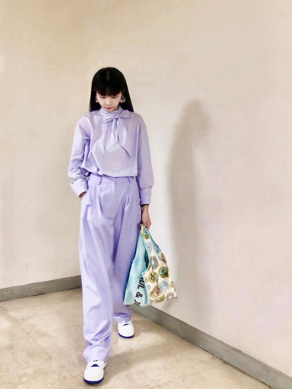 パープル系のシャツ/ブラウス、パープル系のスーツパンツ、ホワイト系のスニーカーを着用したレディースの夏コーディネートの2枚目の写真