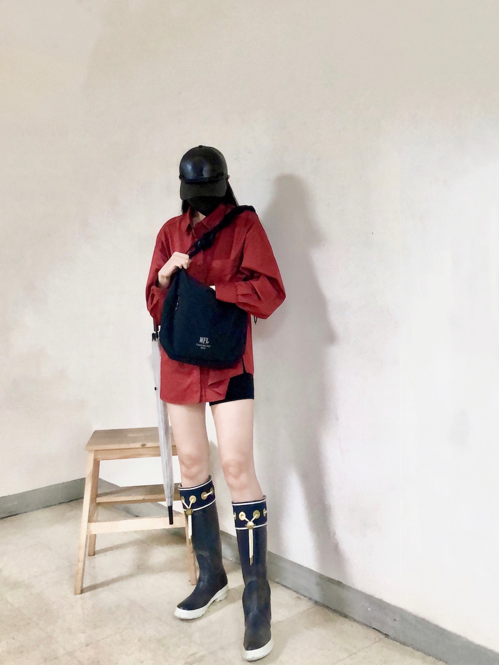 レッド系のシャツ/ブラウス、ブラック系のバッグ、ブルー系のレインシューズを着用したレディースの春コーディネートの3枚目の写真