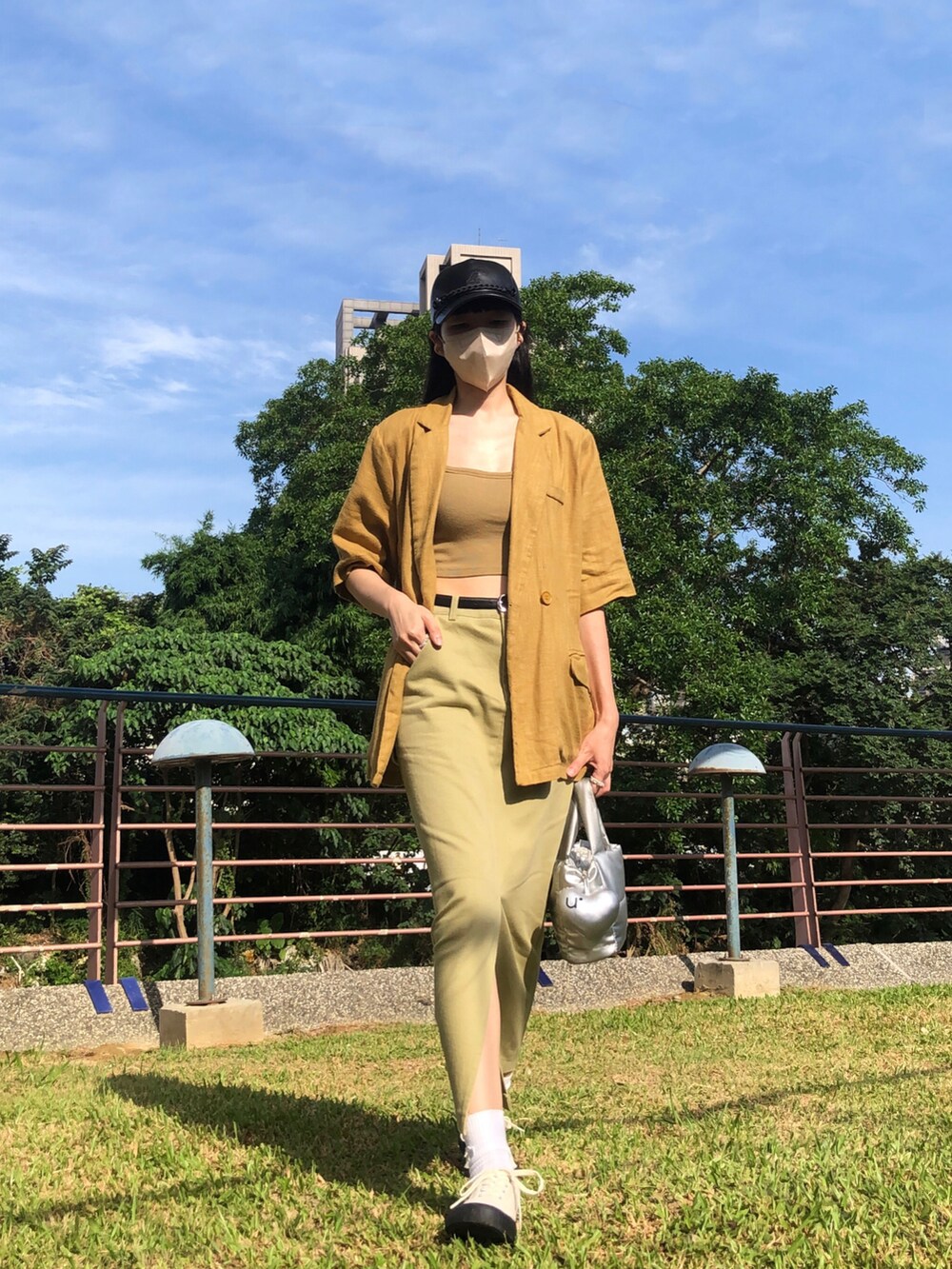 イエロー系のチューブトップ、グリーン系のスカート、イエロー系のスーツジャケットを着用したレディースの夏コーディネートの2枚目の写真