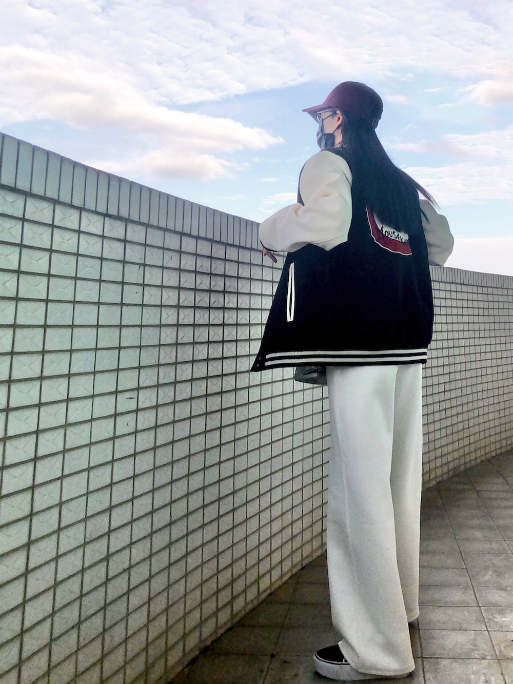 レッド系のトップス、ホワイト系のスラックス、シルバー系のバッグを着用したレディースの冬コーディネートの4枚目の写真