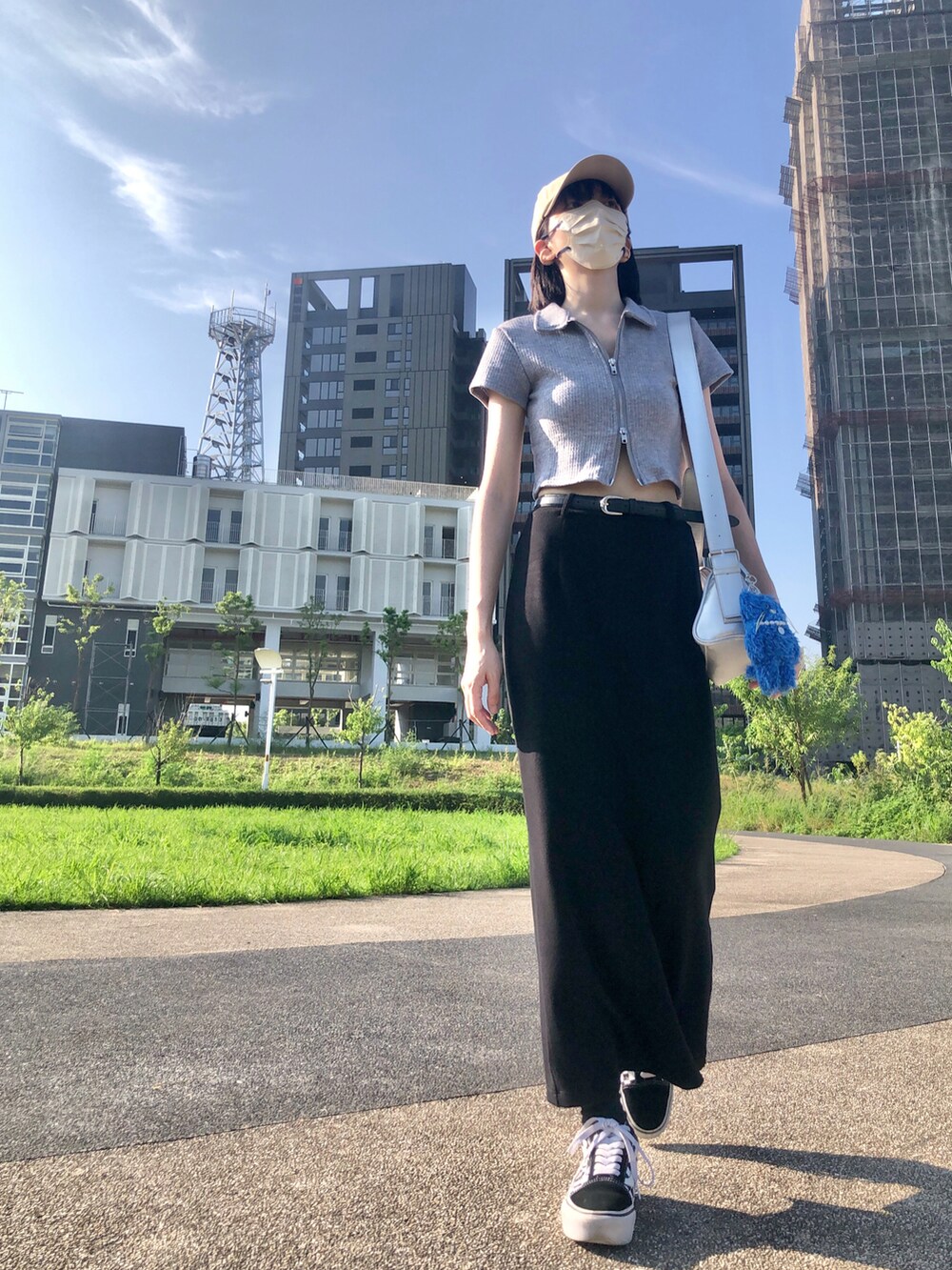 ブラック系のスニーカー、グレー系のポロシャツ、ブラック系のスカートを着用したレディースの夏コーディネートの4枚目の写真