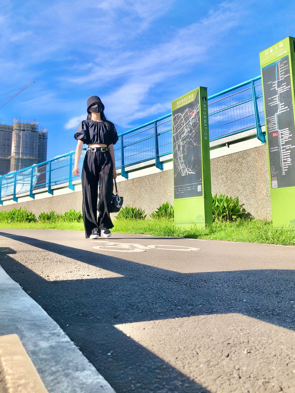ブラック系のトップス、ブラック系のパンツ、ブラック系のバッグを着用したレディースの春コーディネートの2枚目の写真