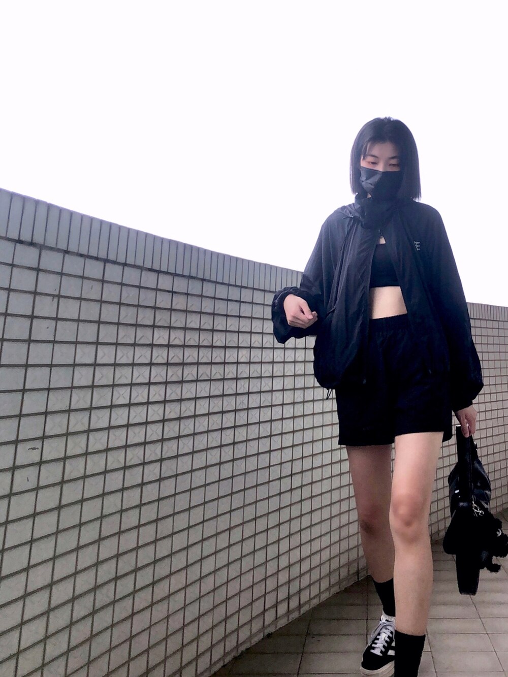 ブラック系のスニーカー、ブラック系のチューブトップ、ブラック系のその他アウターを着用したレディースの秋コーディネートの2枚目の写真