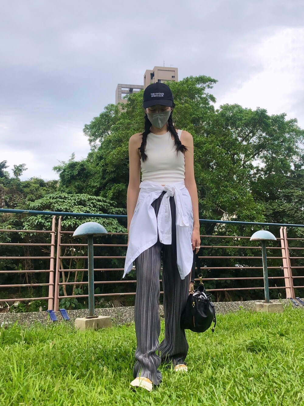 イエロー系のスニーカー、その他のタンクトップ、グレー系のパンツを着用したレディースの夏コーディネートの2枚目の写真