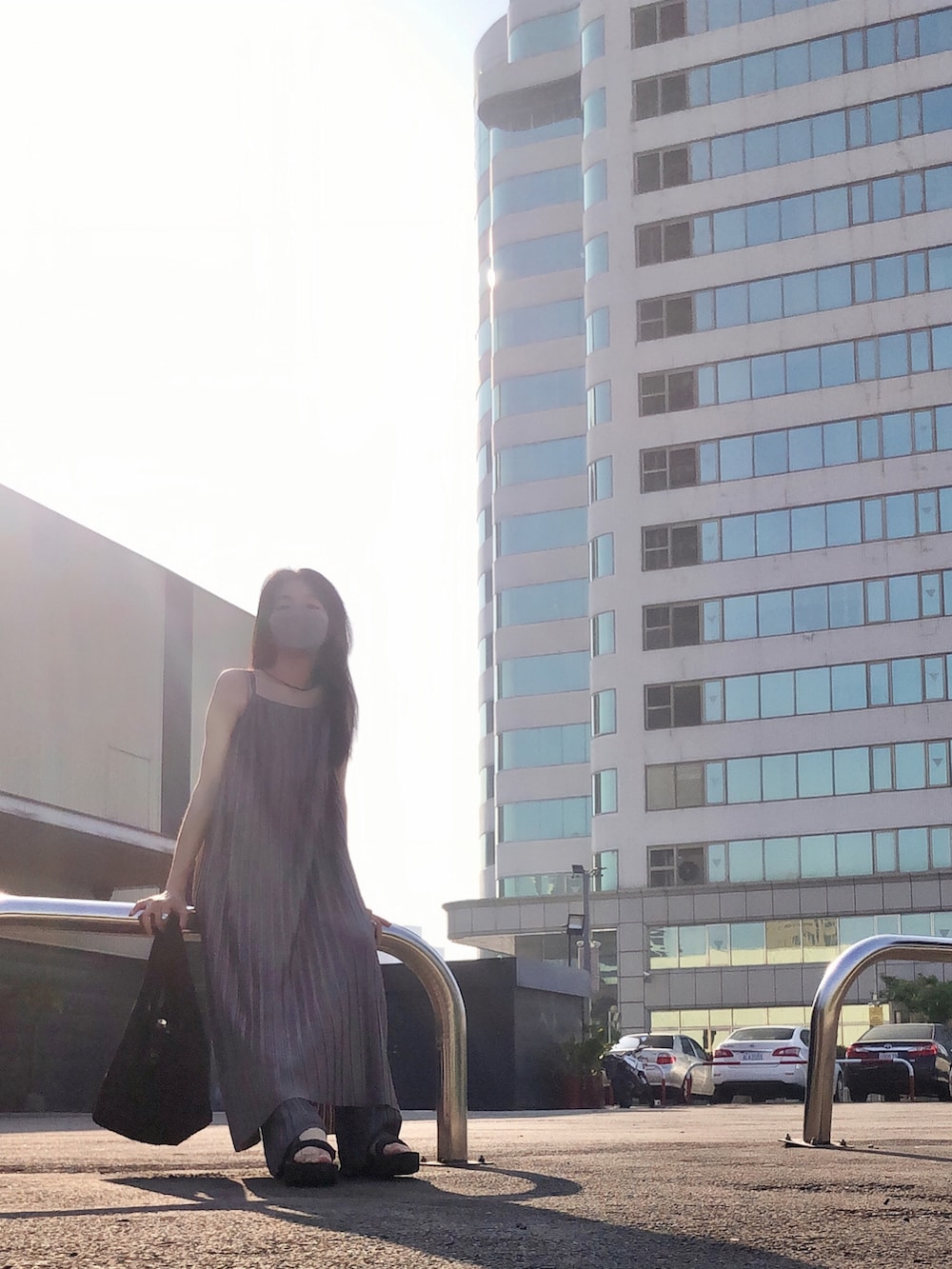 ブラック系のサンダル、グレー系のパンツ、グレー系のジャンパースカートを着用したレディースの秋コーディネートの3枚目の写真