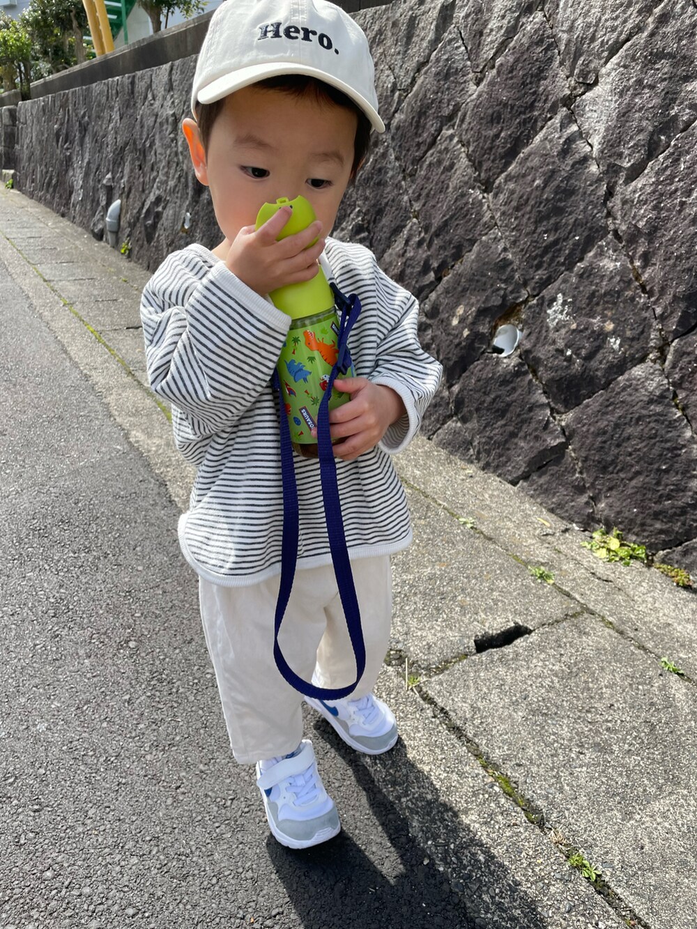 ホワイト系のスウェット、ベージュ系のチノパンツ、ホワイト系のスニーカーを着用したキッズの春コーディネートの2枚目の写真