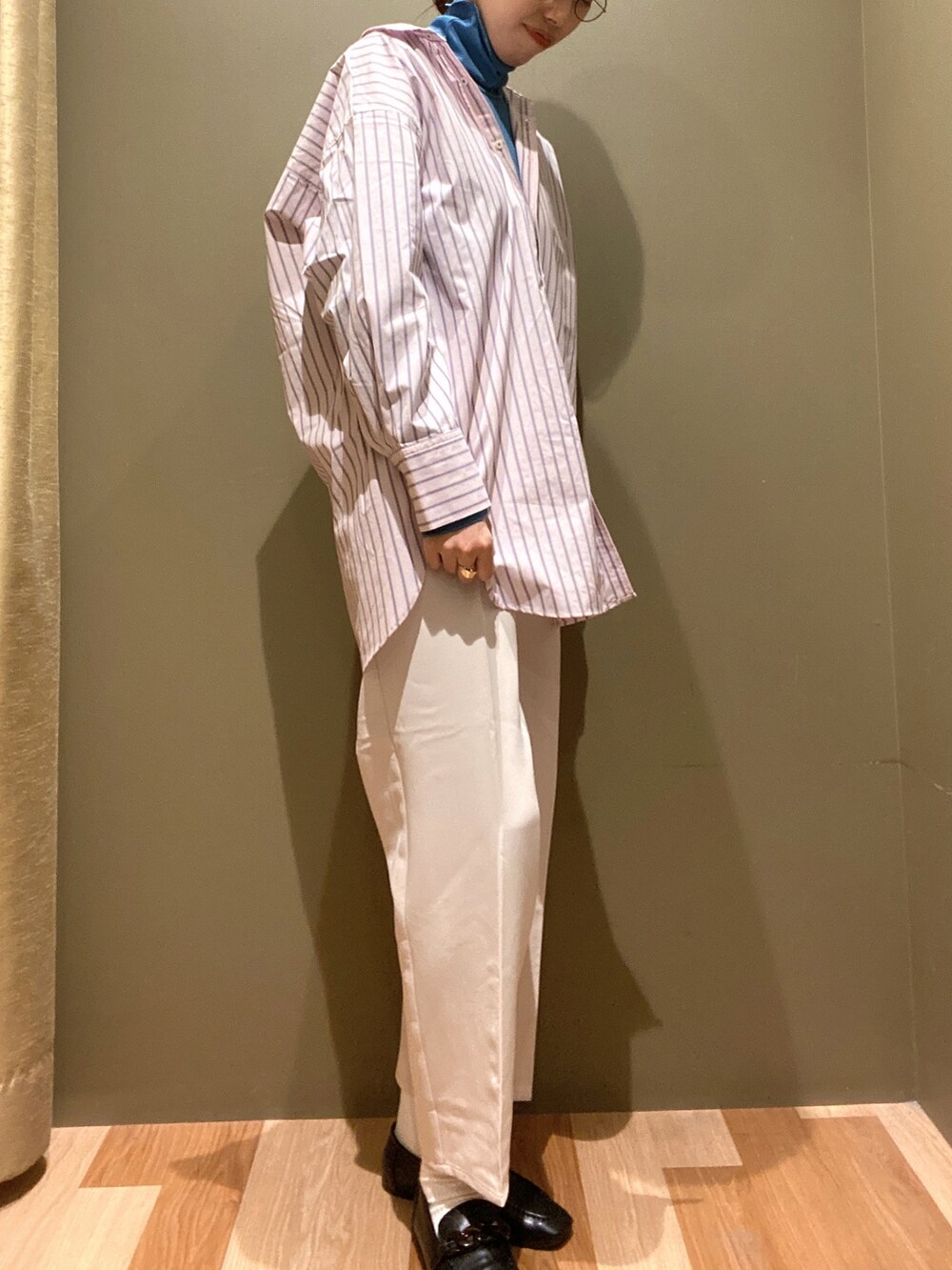 ホワイト系のスラックス、ピンク系のシャツ/ブラウス、ブルー系のTシャツ/カットソーを着用したレディースの冬コーディネートの2枚目の写真