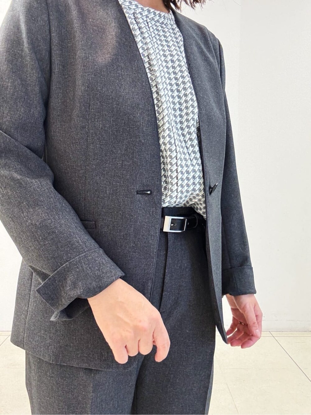 グレー系のスーツジャケット、グレー系のスーツパンツ、ブルー系のシャツ/ブラウスを着用したレディースの秋コーディネートの5枚目の写真