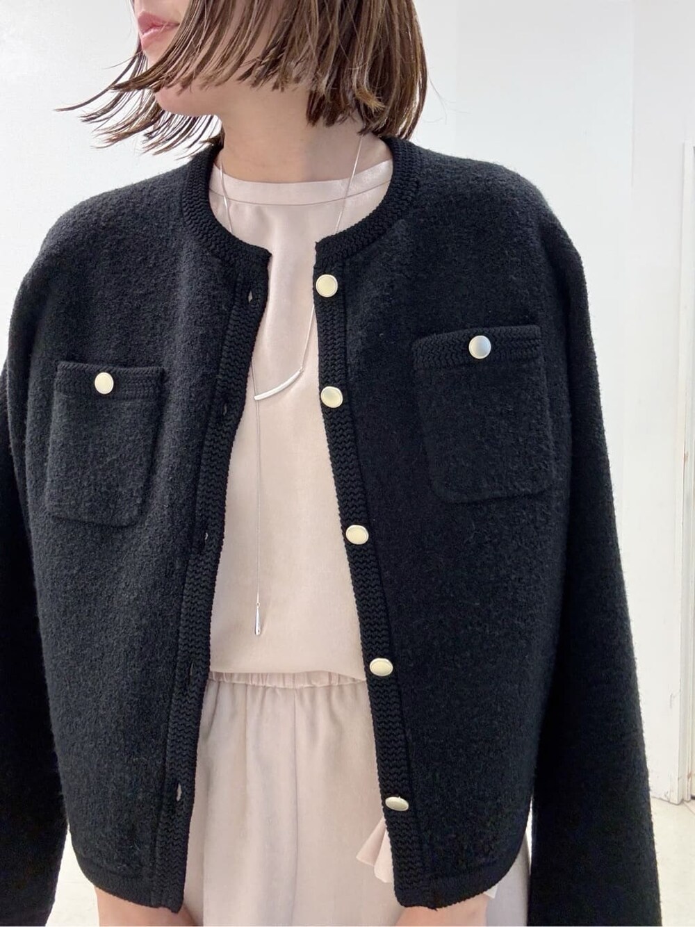 ベージュ系のシャツ/ブラウス、ベージュ系のスカート、ブラック系のカーディガン/ボレロを着用したレディースの冬コーディネートの5枚目の写真