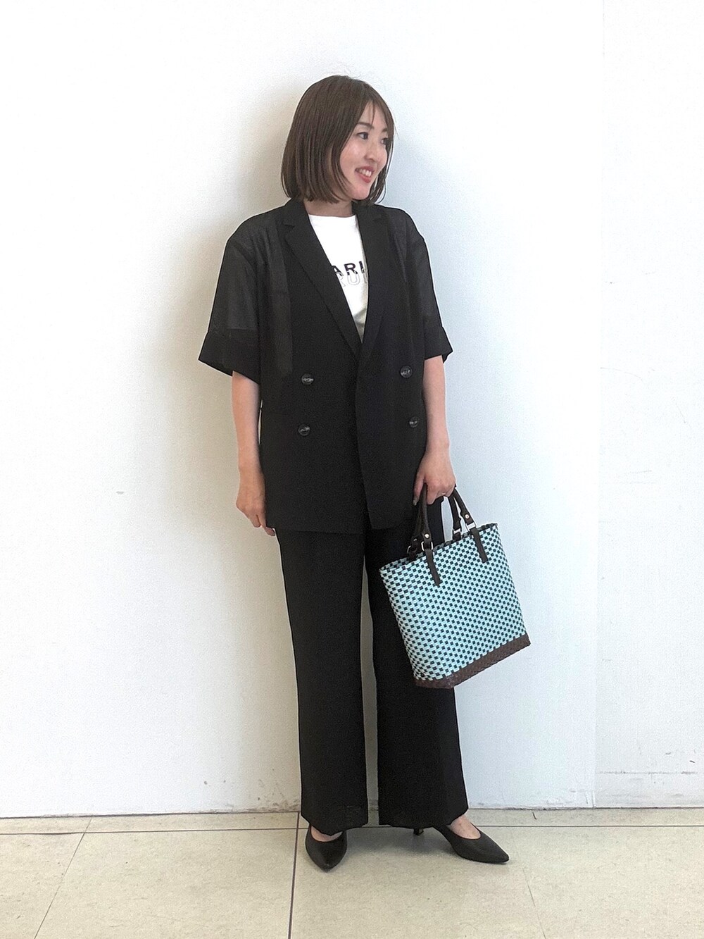 ホワイト系のTシャツ/カットソー、ブラック系のパンプス、ブラック系のテーラードジャケットを着用したレディースの春コーディネートの2枚目の写真